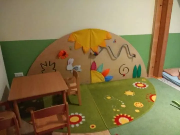 Spielbereich mit bunter Wandgestaltung und kleinem Tisch